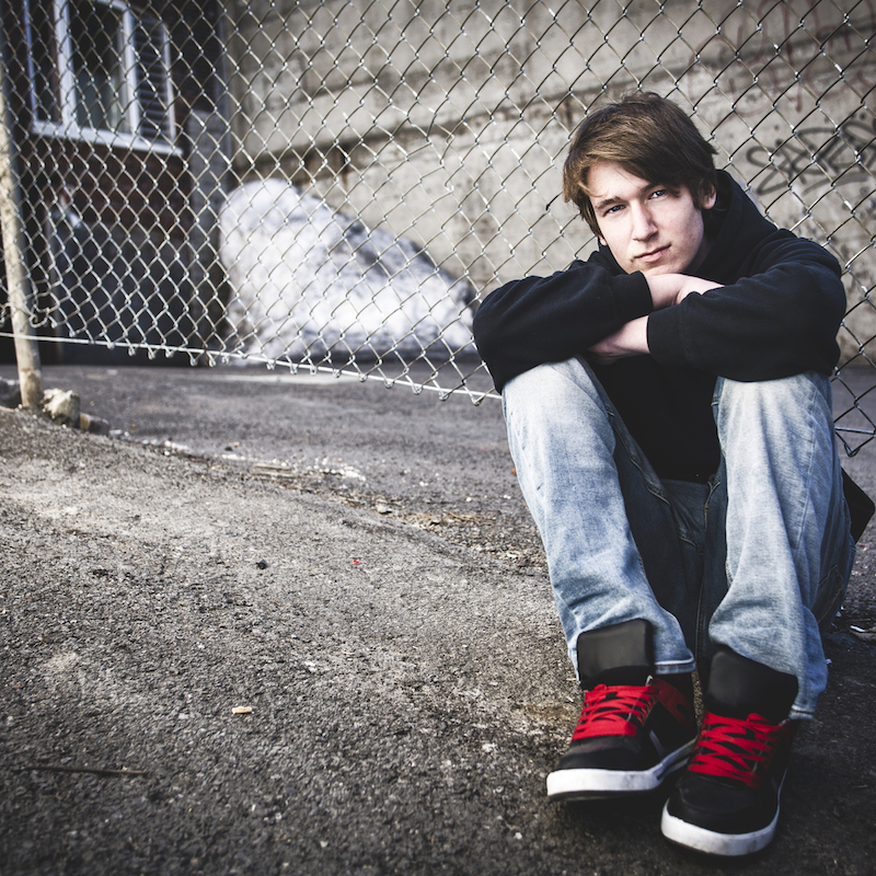 A boy sitting on the pavement